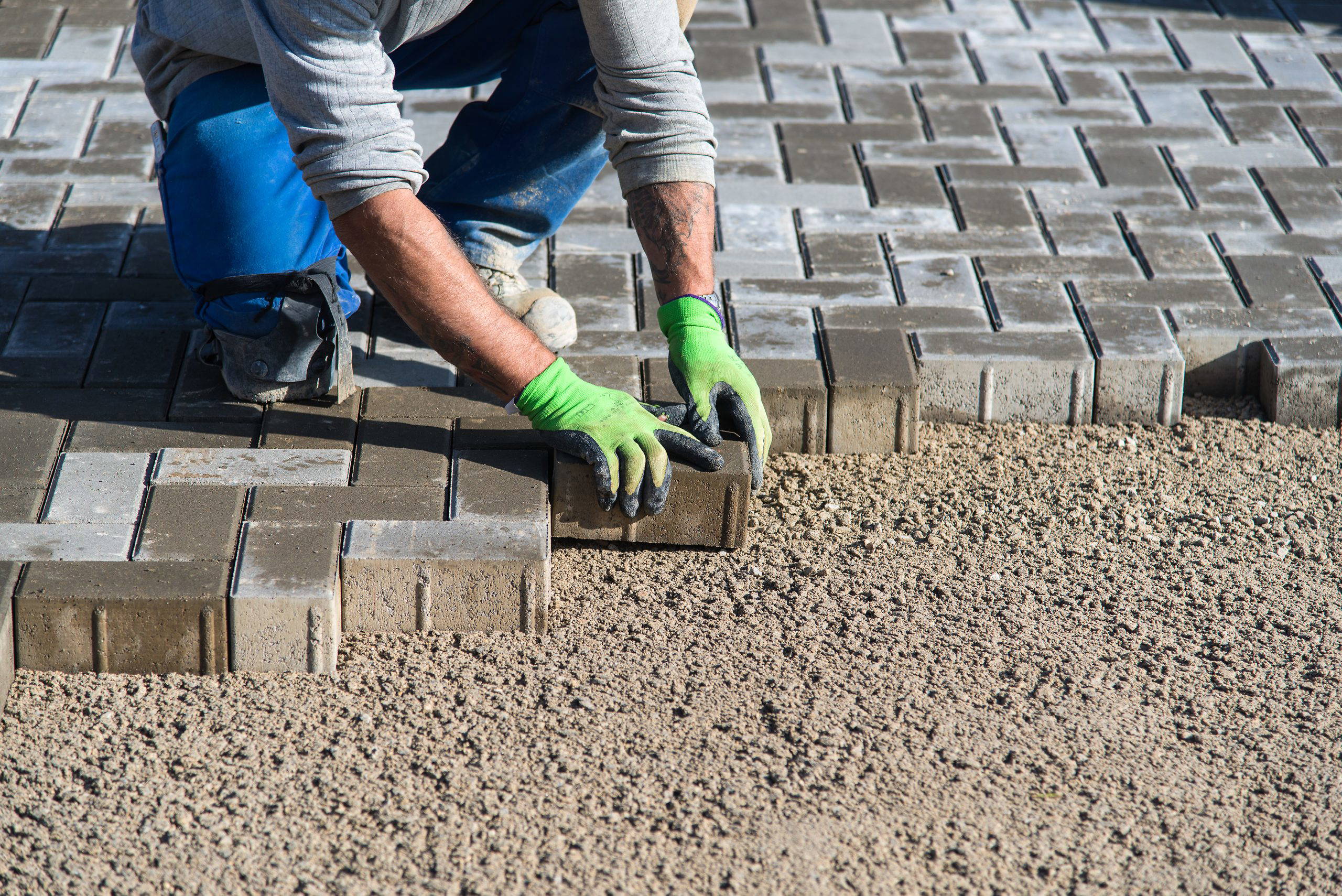 An image of a person laying down block paving.